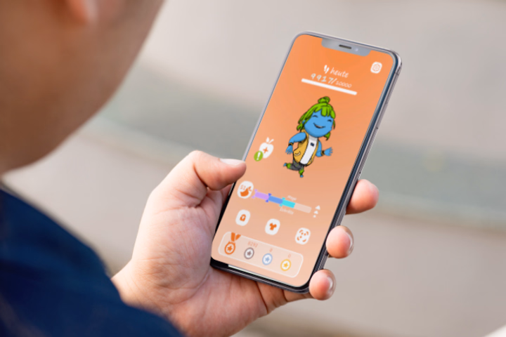 Smartphone-Display zeigt die App POLKI-Go mit dem blauen Maskottchen POLKI in Wander-Outfit auf einem Schrittzähler-Interface.